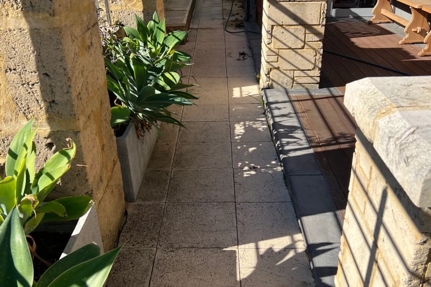 Before and after cleaning on sandstone pavers · Path: before