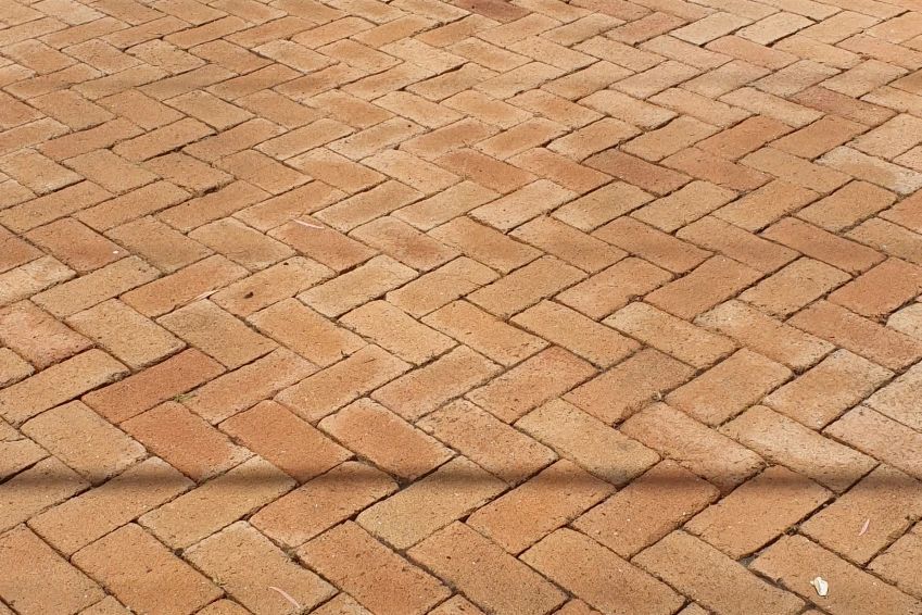 Before and after cleaning on brick pavers · Driveway: after