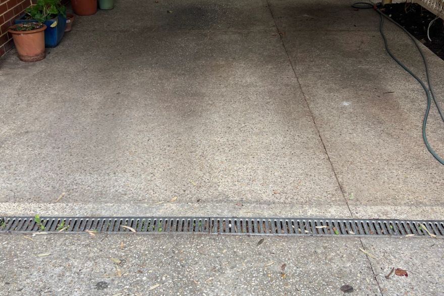 Before and after cleaning on concrete exposed aggregate · Garage floor: before
