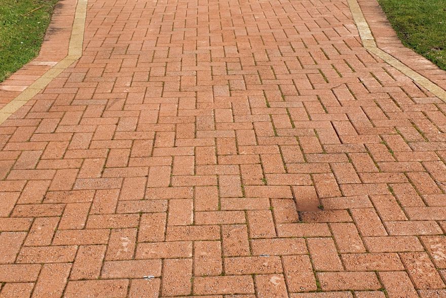 Before and after cleaning on brick pavers · Driveway: after