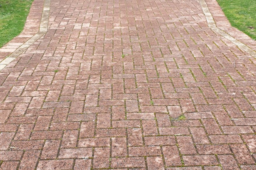 Before and after cleaning on brick pavers · Driveway: before