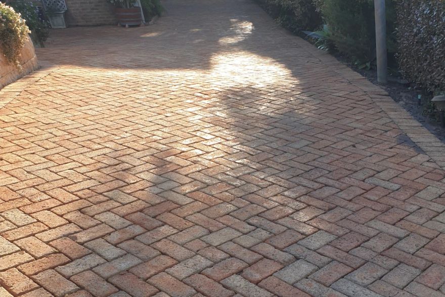 Before and after cleaning on brick pavers · Driveway: after