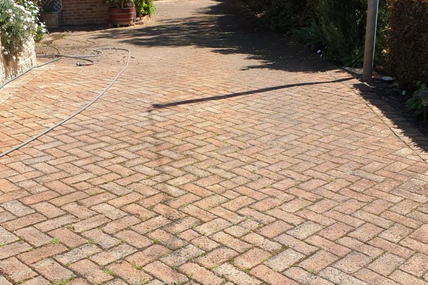 Before and after cleaning on brick pavers · Driveway: before