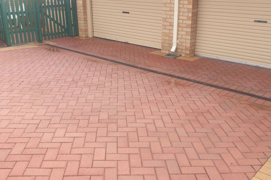 Before and after cleaning on brick pavers · Driveway: after