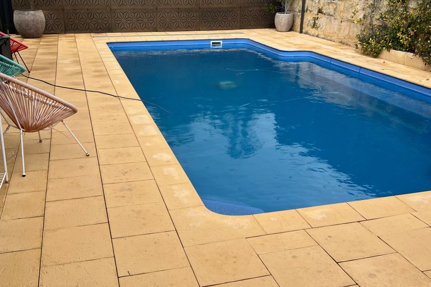 Before and after cleaning on sandstone pavers · Poolside: after