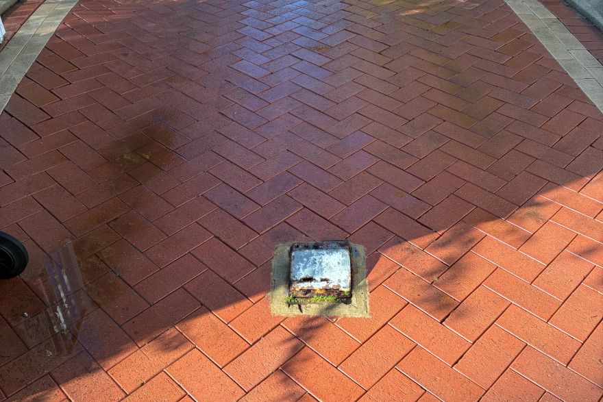 Before and after cleaning on brick pavers · Driveway: after