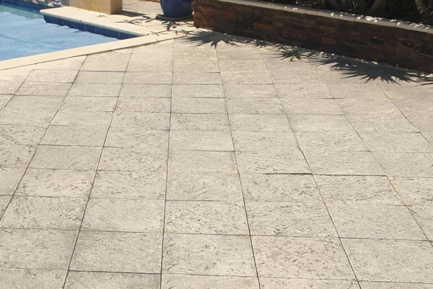 Before and after cleaning on sandstone pavers · Poolside: before