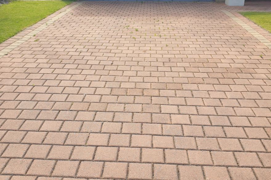 Before and after cleaning on brick pavers · Driveway: before
