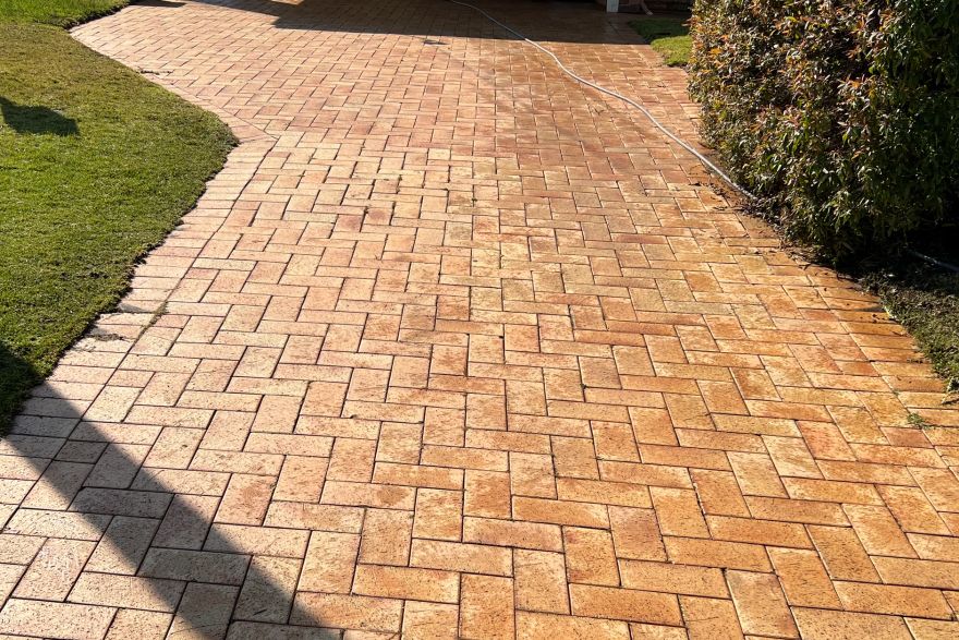 Before and after cleaning on brick pavers · Driveway: after