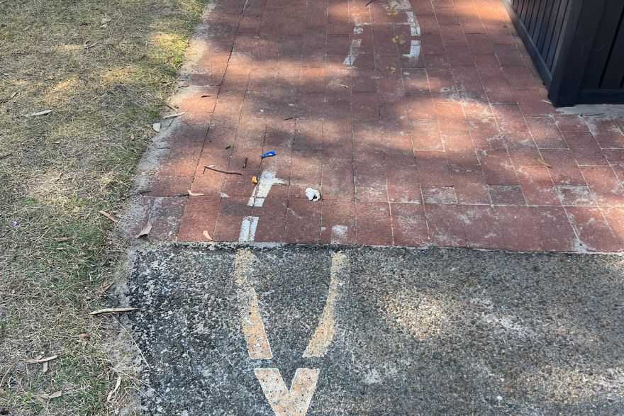 Before and after paint removal on brick pavers: before