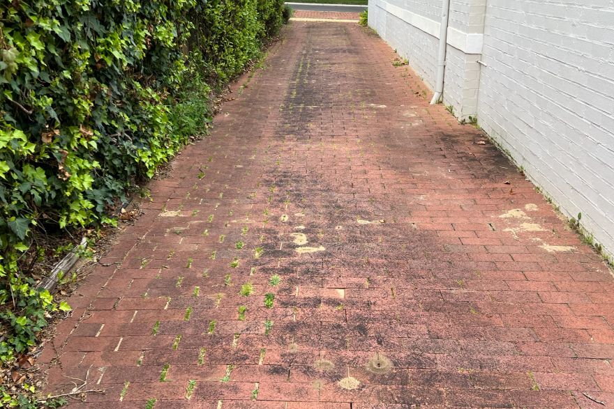 Before and after cleaning on brick pavers · Driveway: before