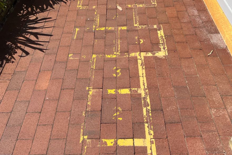 Before and after paint removal on brick pavers: before
