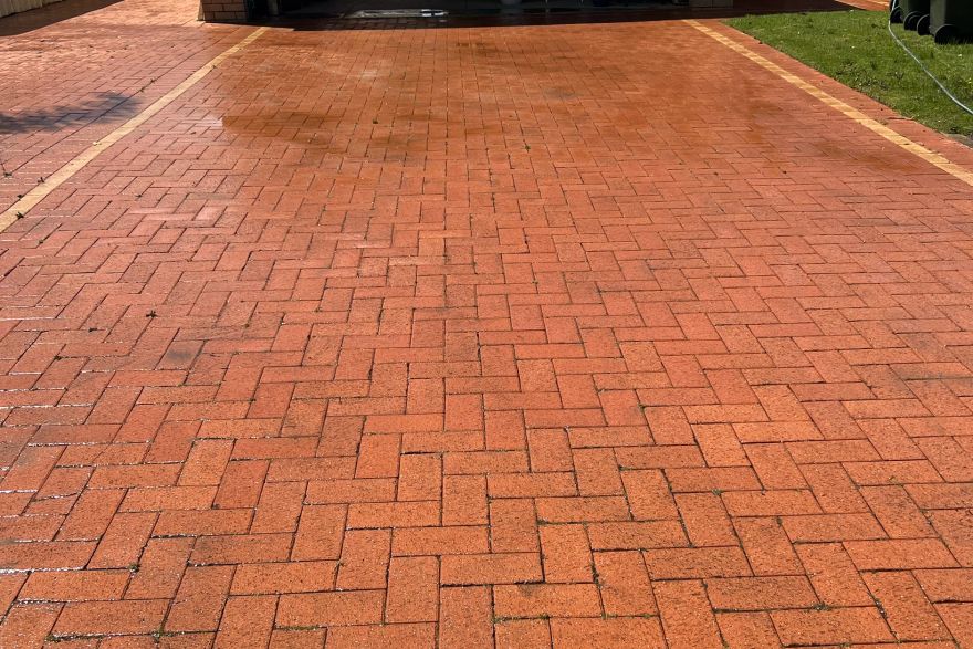 Before and after cleaning on brick pavers · Driveway: after