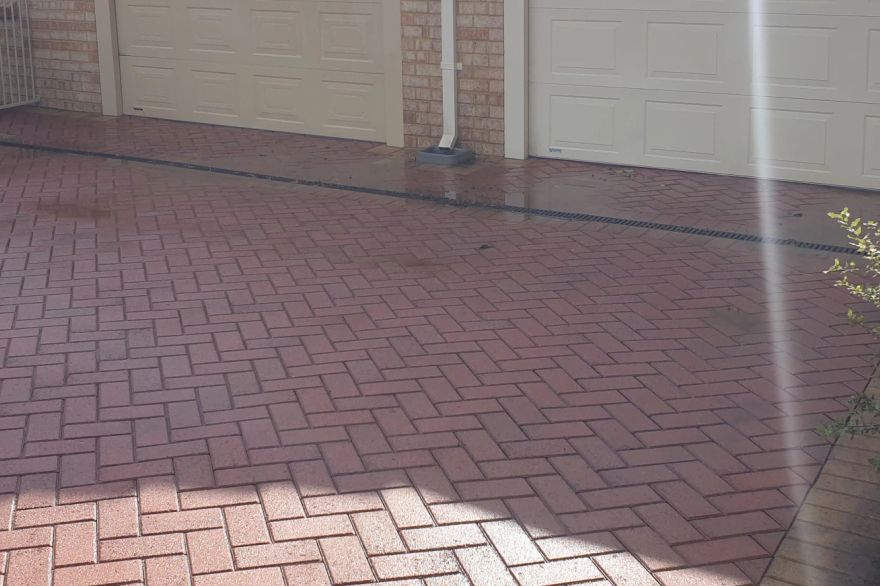 Before and after cleaning on brick pavers · Driveway: after