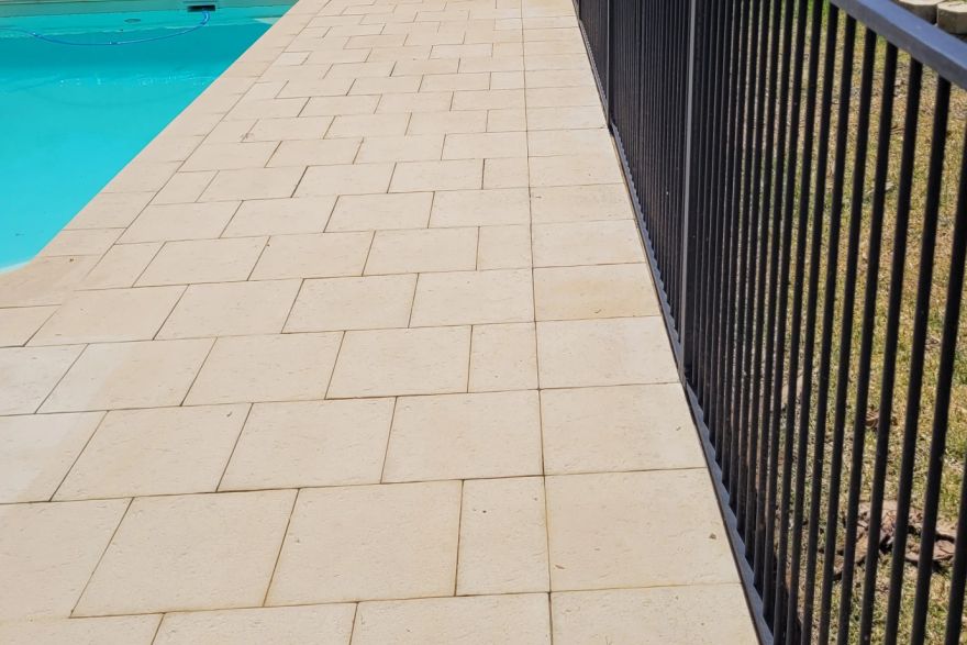 Before and after cleaning on sandstone pavers · Poolside: after