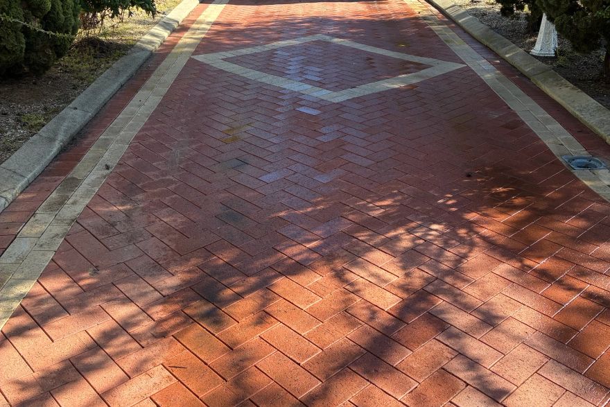Before and after cleaning on brick pavers · Driveway: after
