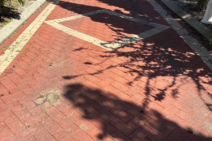Before and after cleaning on brick pavers · Driveway: before