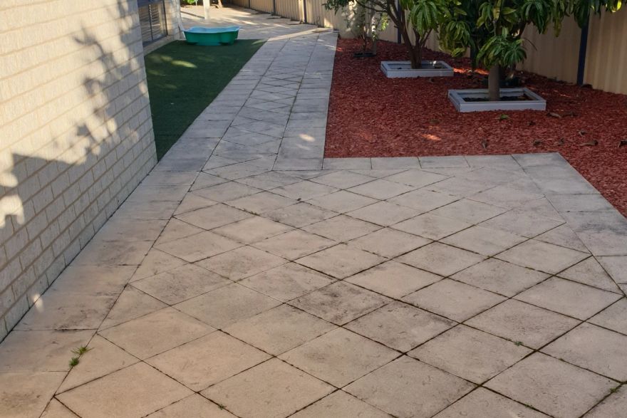 Before and after cleaning on sandstone pavers · Side of house: before