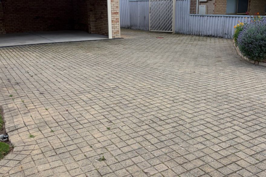 Before and after cleaning on brick pavers · Driveway: before