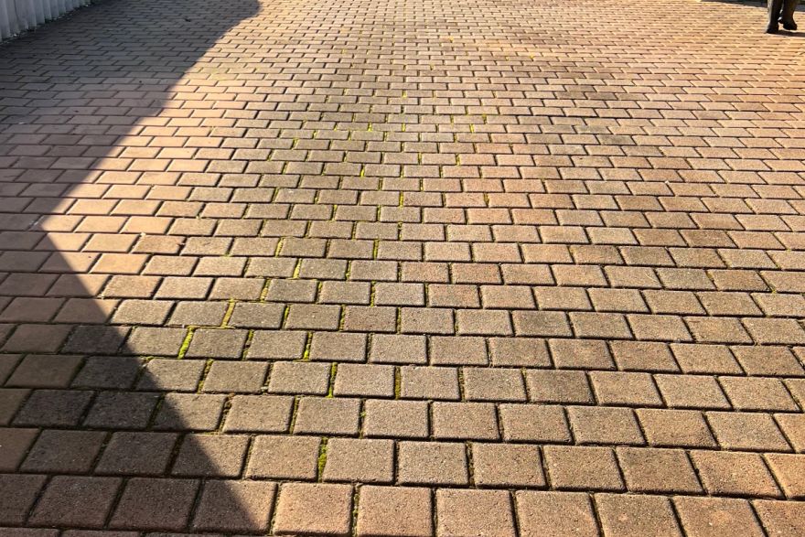 Before and after cleaning on brick pavers · Driveway: before