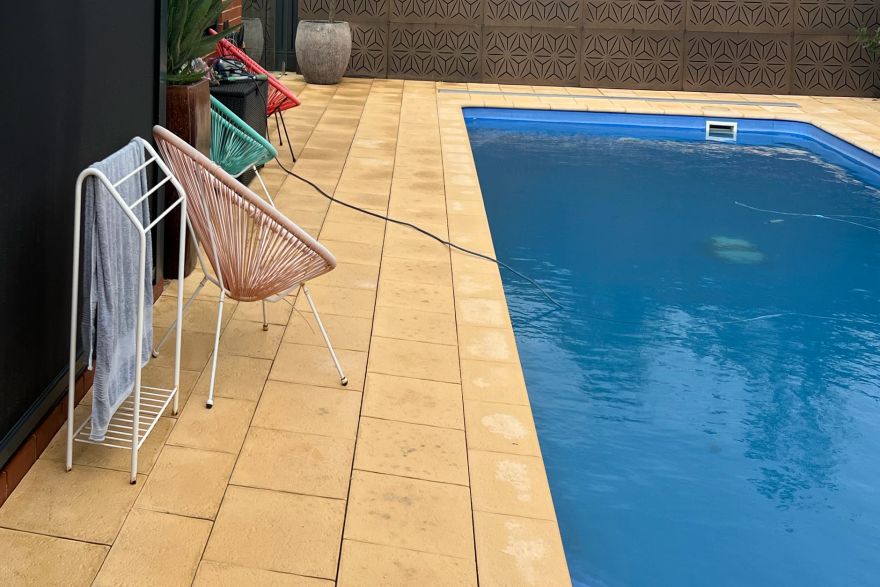 Before and after cleaning on sandstone pavers · Poolside: after