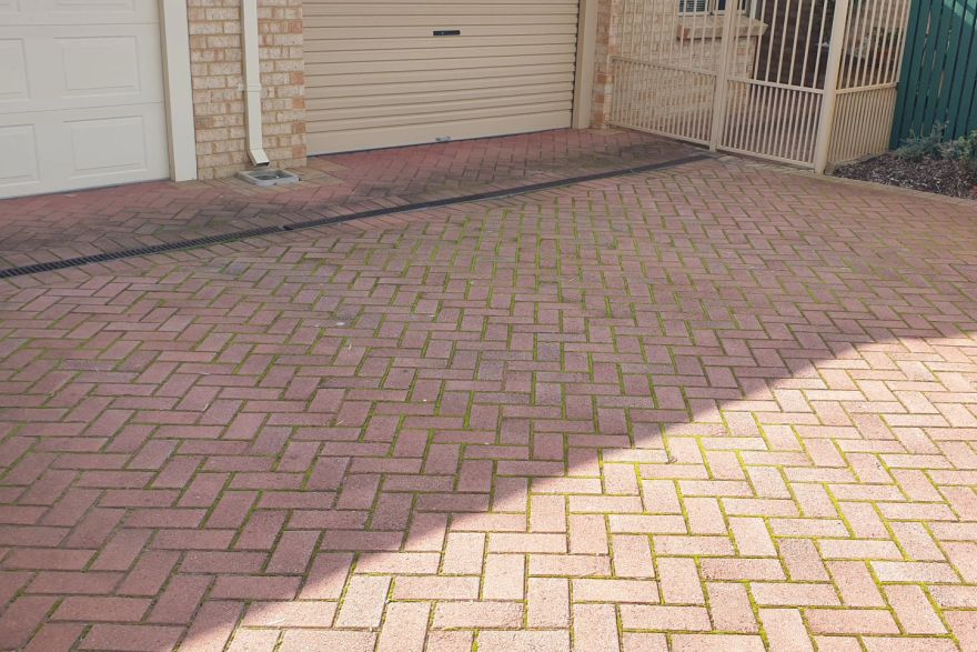 Before and after cleaning on brick pavers · Driveway: before