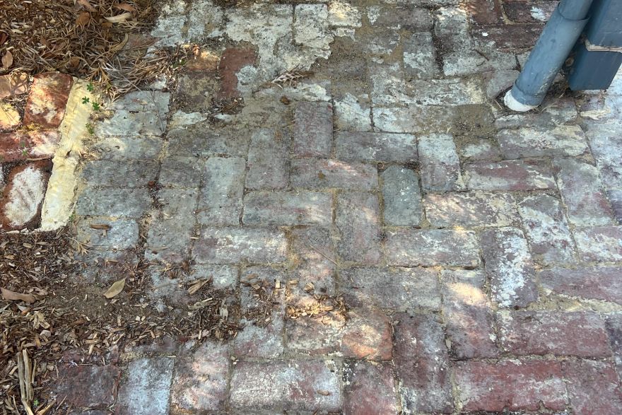 Before and after cleaning on brick pavers: before