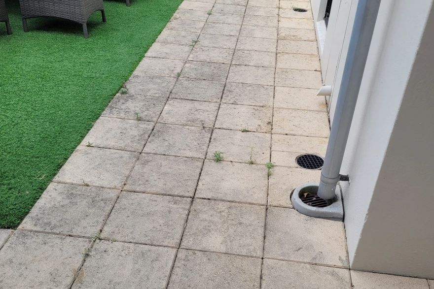 Before and after cleaning on sandstone pavers: before