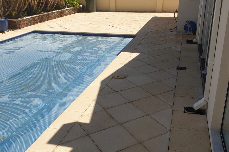 Before and after cleaning on sandstone pavers · Poolside: after