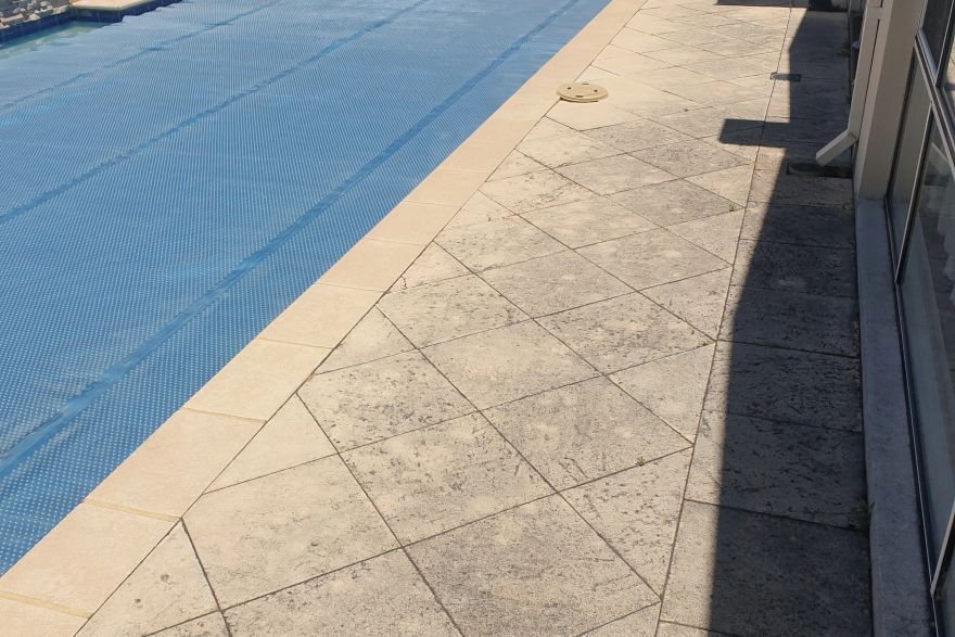 Before and after cleaning on sandstone pavers · Poolside: before
