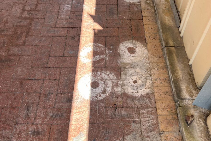 Before and after paint removal on brick pavers: before