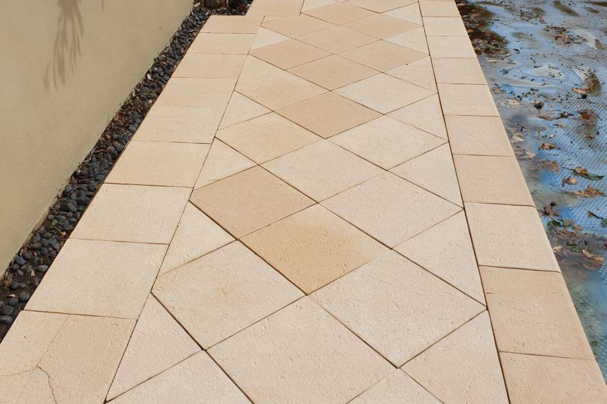 Before and after cleaning on sandstone pavers · Poolside: after