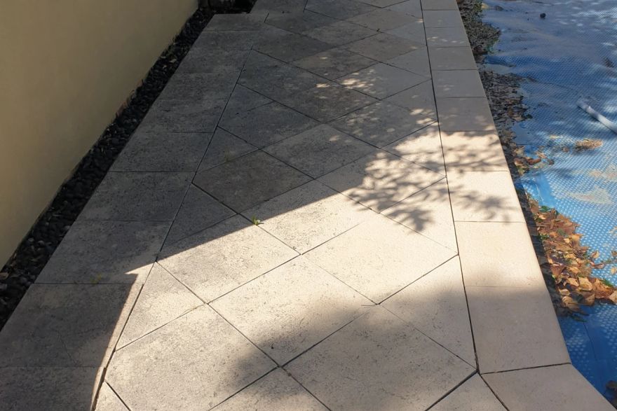 Before and after cleaning on sandstone pavers · Poolside: before