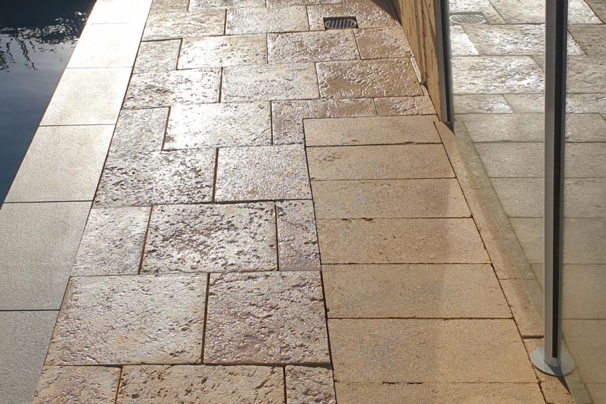 Before and after cleaning on sandstone pavers · Poolside: after