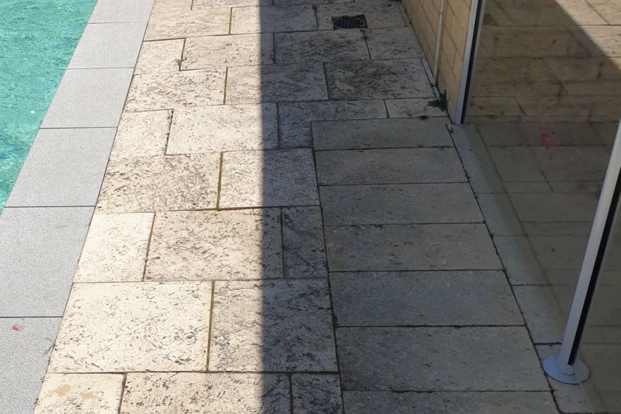 Before and after cleaning on sandstone pavers · Poolside: before