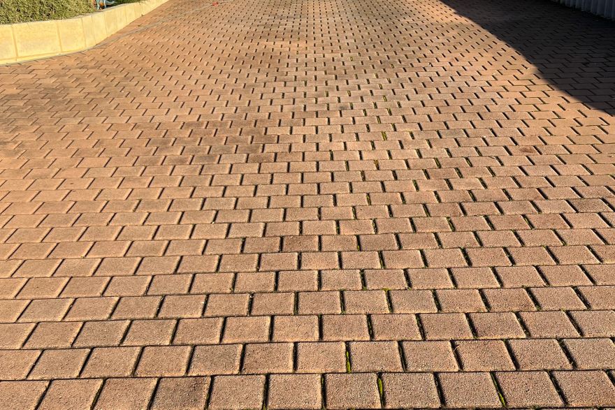 Before and after cleaning on brick pavers · Driveway: before