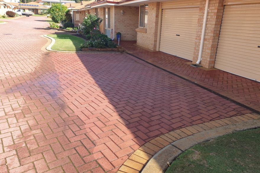 Before and after cleaning on brick pavers · Driveway: after