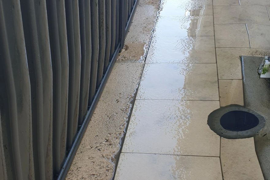 Before and after cleaning on sandstone pavers · Side of house: after