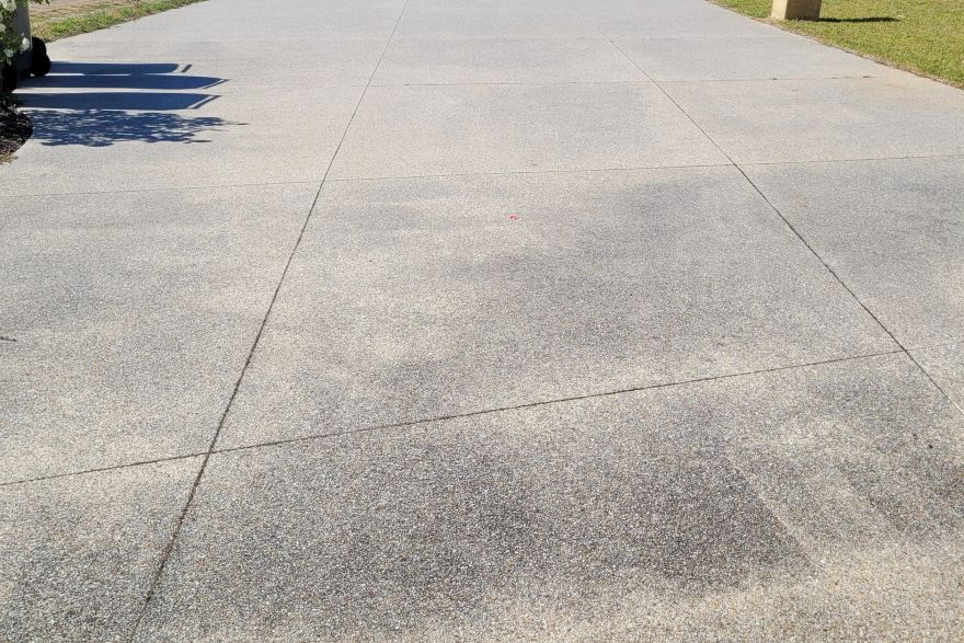 Before and after cleaning on concrete exposed aggregate · Driveway: before