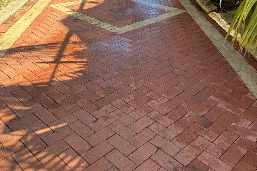 Before and after cleaning on brick pavers · Driveway: after