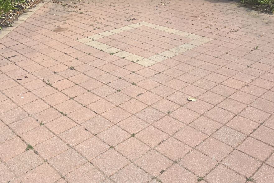 Before and after cleaning on brick pavers · Driveway: before