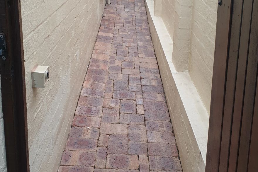 Before and after cleaning on brick pavers · Path: after