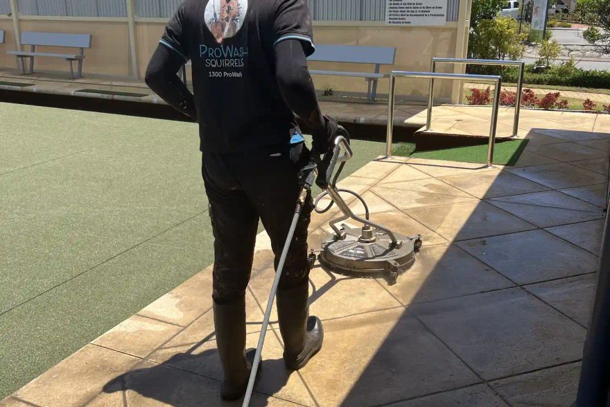 Michael cleaning paving beside a retirement village bowling green.