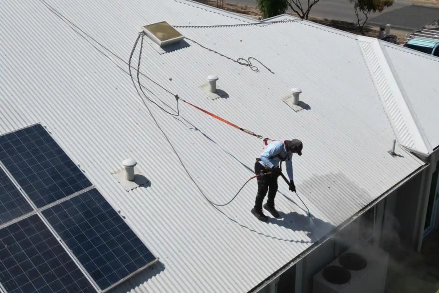 Michael pressure cleaning a metal roof during an earlier ProWash job.