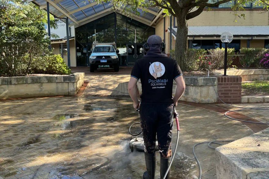Michael pressure cleaning paving outside a school entrance.