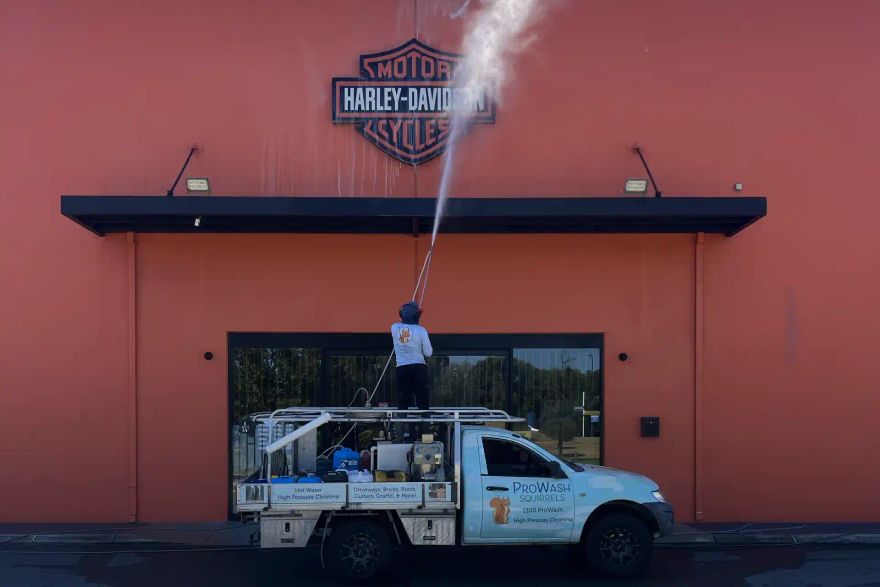 Michael pressure cleaning a shop façade with the ProWash Squirrels ute outside.